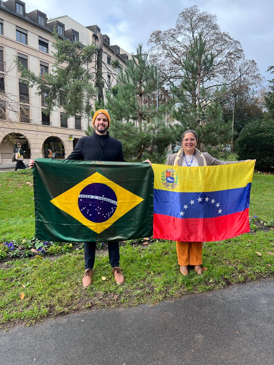 Representantes da REDEVEN no Foro Global dos Refugiados, com as bandeiras do Brasil e da Venezuela