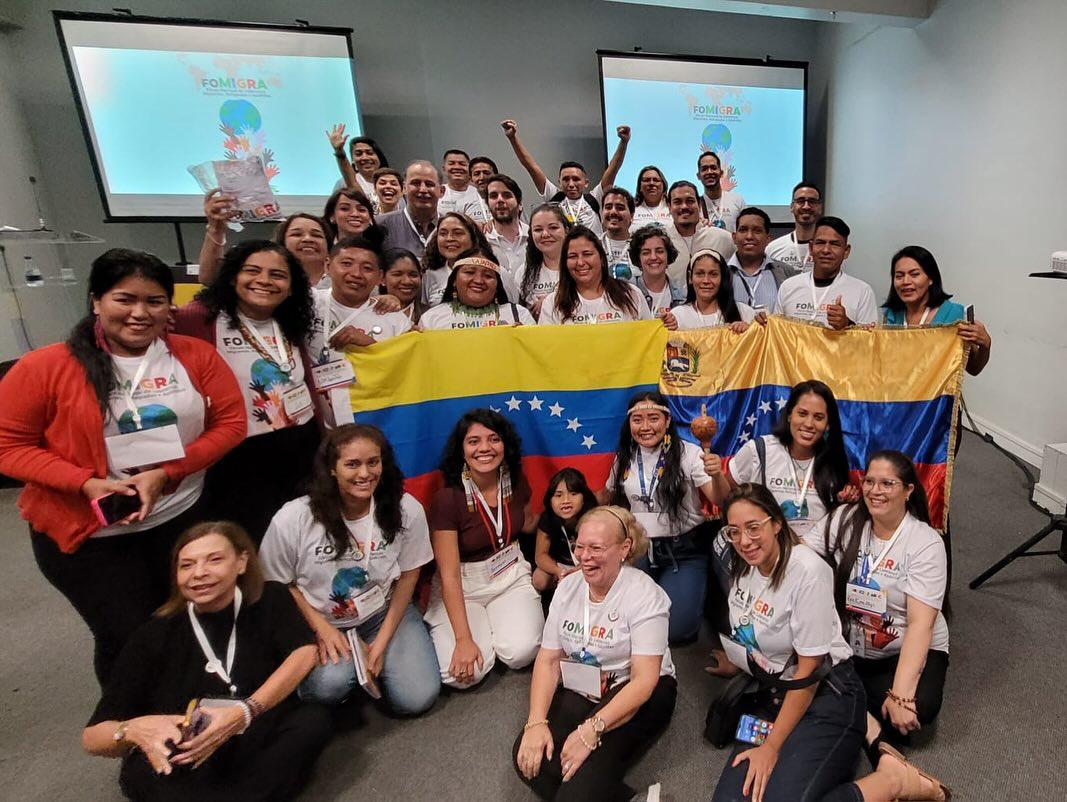 Lideranças e organizações venezuelanas reunidas em evento da rede REDEVEN, com a bandeira da Venezuela